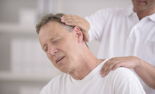 Man with osteochondrosis of neck receiving manual massager